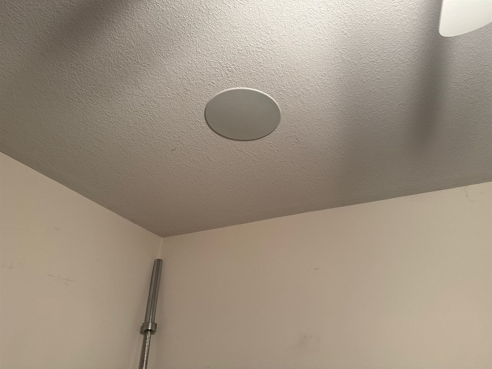 In-ceiling speaker installed flush in a textured ceiling