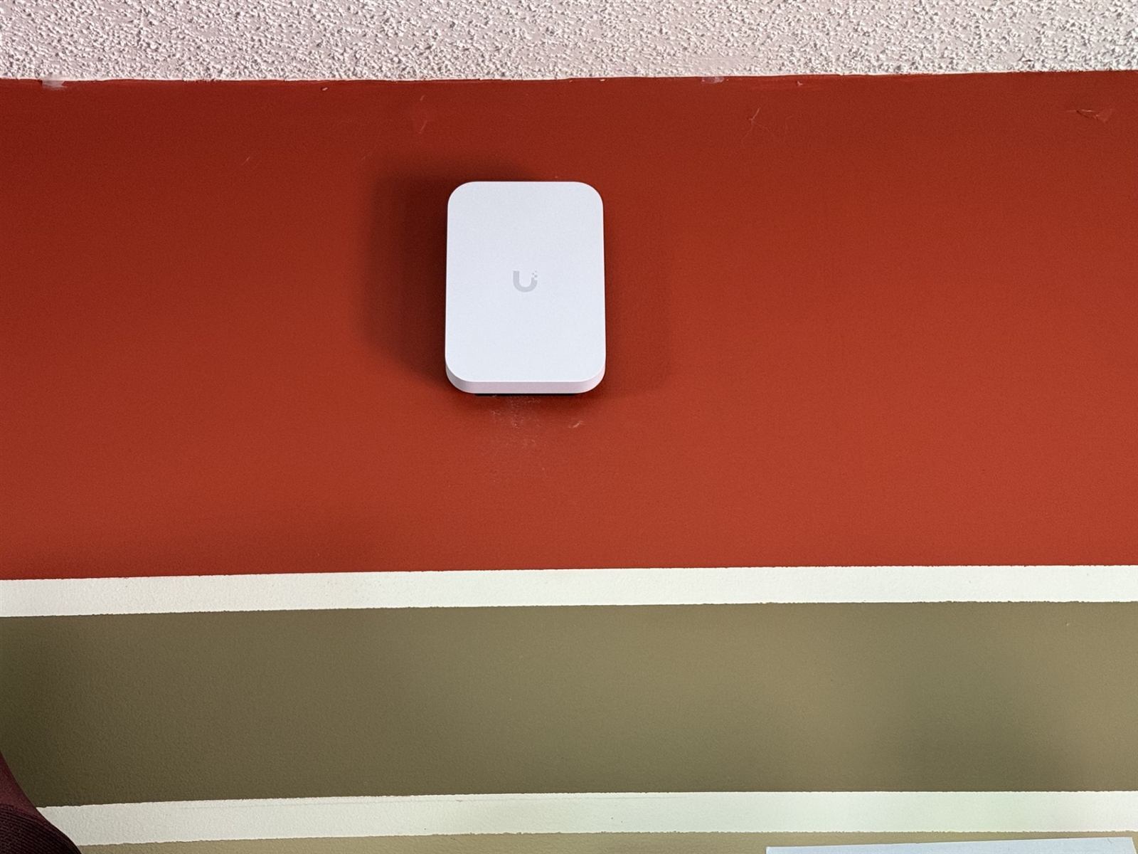 Ubiquiti UniFi access point wall-mounted on a kitchen wall to extend Wi-Fi coverage